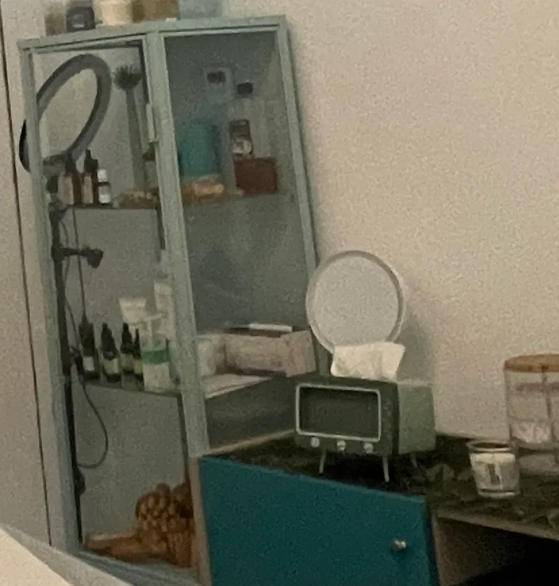 Rincón de la cabina con aro de luz, espejo y productos de cuidado